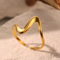 Minimalistischer, wellenförmiger, goldener Ring auf einem rustikalen Steinsockel - Goldwellen-Stil (C3377)