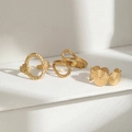 Detalle de tres anillos geométricos de acero inoxidable dorado en pedestal blanco - Juego de 3 Piezas Dorado (C8637)