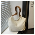 Close-up of cream canvas tote bag with brown straps in soft natural sunlight - White and Brown