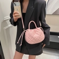 Pink quilted bucket bag with diamond pattern and gold hardware on black blazer - Pink