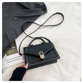 Dettaglio borsa in pelle nera con chiusura a scatto dorata e trama raffinata ed elegante - Nero