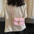 Piccola borsa a tracolla rosa con fibbia a ferro di cavallo indossata da modella - Rosa