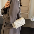 White quilted chain flap bag made of PU leather worn with a grey suit for a trendy style - Off White