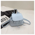 Detail des hellblauen Mini-Rucksacks mit Kordelzug und geprägter Klappenstruktur - Cremeblau
