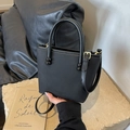 Minimalist black embossed leather handbag with gold hardware and top handle strap - Black