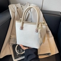 Chic white trapezoid handbag with beige trim and purple ball accents on handles - Khaki and White