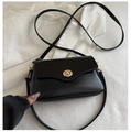 Close-up of shiny patent leather crossbody bag with elegant gold oval twist lock closure - Black