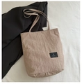 Borsa tote beige minimalista con texture stropicciata su un blazer nero per look chic - Cachi Scuro