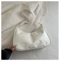 Détail d'un sac bandoulière en cuir beige avec coutures fines sur tissu en velours - Blanc