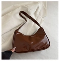 Détail d'un sac hobo en cuir verni marron foncé brillant avec finition lisse - Marron