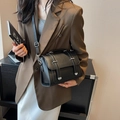 Classic black leather crossbody bag with dual silver buckles and adjustable strap - Black