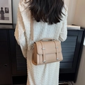 Beige minimalist crossbody bag with silver hardware on a female model with knit dress - Khaki