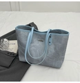 Detalle del bolso tote gris azulado con ribete en azul claro y placa metálica de logo - Azul
