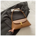 Detalle de bolso baguette de cuero sintético marrón con cierre de metal dorado en blazer - Marrón