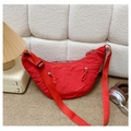 Detail of red crescent bag featuring pleated nylon texture and woven rope zipper pulls - Red