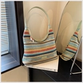 Macro detail of colorful woven rainbow tote bag with light green leather handle and beads - Colorful