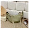 Detail of grass green nylon croissant bag with wide strap on cozy home background - Dark Khaki