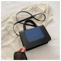 Detalle de bolso elegante con ribete de piel sintética negra y paneles de denim azulado - Negro & Azul