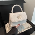 Elegant cream quilted handbag with gold M logo in a black luxury gift box setting - White