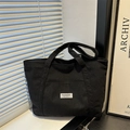Minimalist black corduroy tote bag with vertical texture and white fashion patch - Black