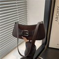 Detail of dark brown baguette bag featuring leather patchwork and silver square buckle - Brown