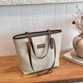 Bolso tote retro crema mate con asas de cuero marrón y placa de marca en la mesa - Blanco Roto