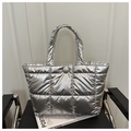 Detail view of silver metallic quilted tote bag with soft padded texture and snap button - Silver
