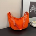 Detail of orange nylon crescent bag showing textured fabric and knotted side cords - Neon Orange