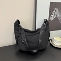 Detail of black nylon dumpling bag with adjustable strap and braided zipper pull - Black