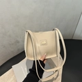 Detail der beigen Kunstledertasche mit schmalen Doppelriemen und elegantem Metall-Logo - Khaki