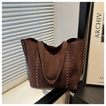 Close-up of brown suede tote bag featuring intricate silver stud rivet detailing on the side - Brown