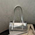 Detail of silver metallic shoulder bag with golden buckles on grey textured background - Silver