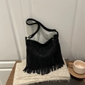 Detail of bohemian black suede hobo bag featuring long tassels and adjustable shoulder strap - Black
