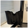 Detail of black suede tote bag with silver studs on window ledge background - Black