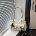 White bowling shoulder bag with dual cargo pockets and vintage wooden bead pendant detail - White