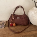 Grande borsa tote marrone retrò con ciondolo a nappa e tracolla su superficie di legno - Con Ciondolo / Marrone