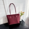 Detailed view of burgundy leopard print tote bag on a black table with yellow tulips - Burgundy