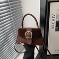 Retro dark brown leather handbag with gold buckle and拼接 textures in artistic natural light - Brown