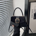 Minimalist black crossbody bag with gold horseshoe buckle and suede texture details - Black