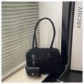 Detail of black minimalist pillow bag with matte finish and detachable coin purse accessory - Black