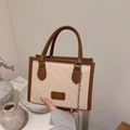 Dettaglio della borsa shopper a scacchi con manici in pelle marrone e catena argento - Cachi