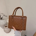 Dettaglio della borsa in ecopelle marrone con motivo a scacchi e logo in metallo - Marrone