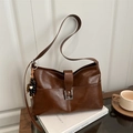 Vintage bruine leren shopper met zilveren gesp en houten kralen hanger op een wit boek - Met Hanger / Bruin