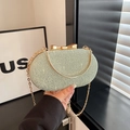 Macro shot of mint green evening bag with 3D texture and gold bow clasp detail - Green