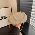 Detail of champagne gold lace evening bag featuring a metal bow clasp and metal handle - Gold