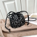 Detail of a black drawstring bucket bag with sparkling silver sequins on a trench coat - Silver
