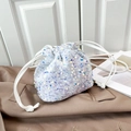 Close-up of drawstring bucket bag featuring iridescent sequins and a white cord handle - White