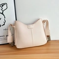 Detail of beige bucket bag with geometric wide strap on a wooden surface - Off White