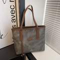 Close-up of industrial grey tote bag texture with brown leather fashion brand tag - Gray