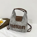 Dettaglio della borsa tote in tela grigia con finiture in pelle marrone e ricamo - Grigio